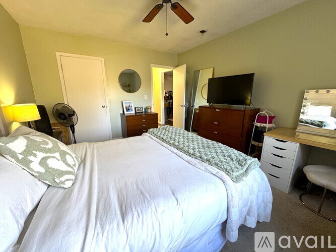 A bedroom with a bed, dresser, and television.