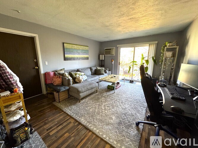 A living room with a couch, a chair, and a painting on the wall.