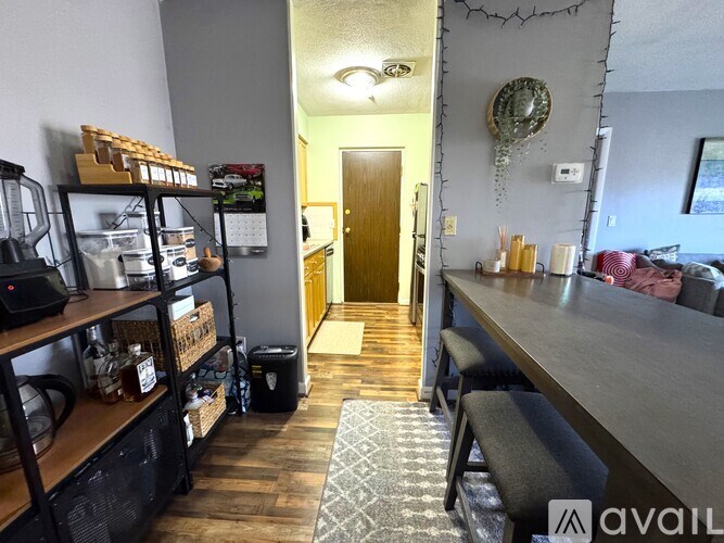 A long wooden table is in the middle of a room with a door in the background.