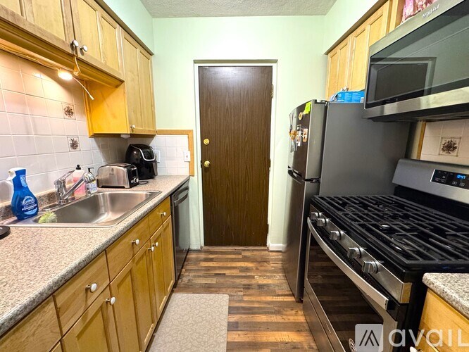 A kitchen with wooden cabinets and a black stove top oven.