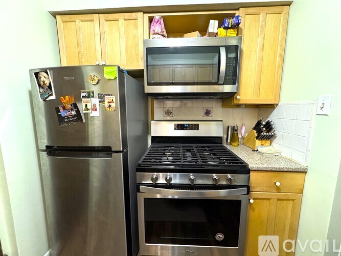 A kitchen with a stainless steel refrigerator, a microwave, and a stove top oven.
