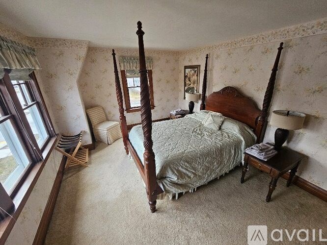 A bedroom with a four poster bed and a window.