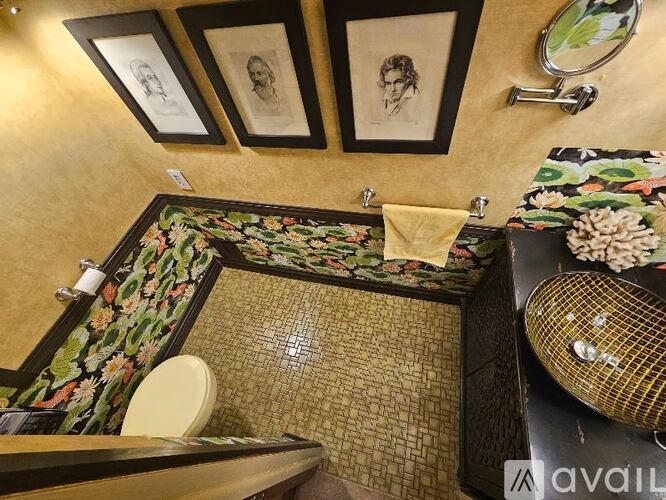 A bathroom with a floral tile floor and a mirror above a sink.