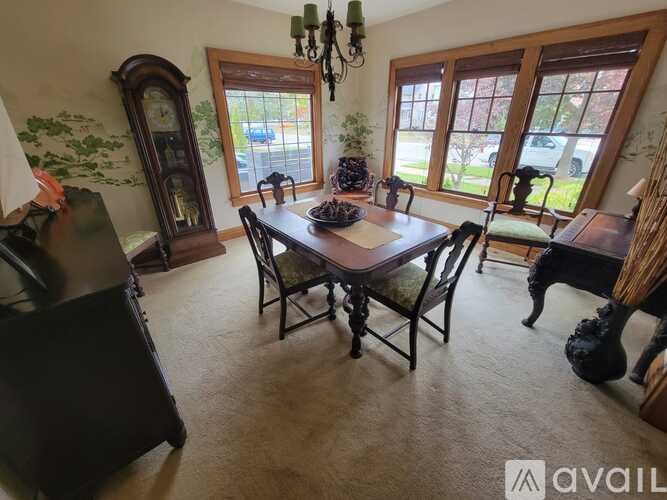 A dining room with a wooden table and chairs.