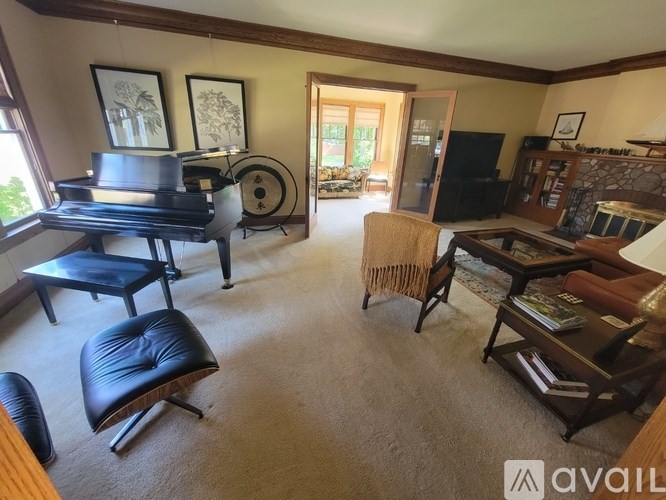 A living room with a piano, two chairs, and a coffee table.