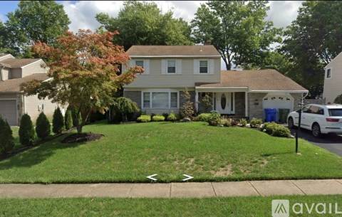 A house with a white car parked in front.
