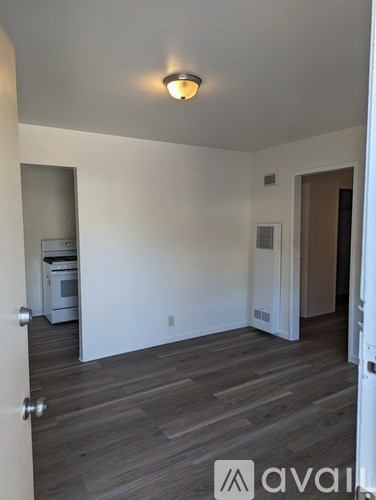 A room with wooden flooring and white walls.