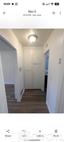 A hallway with a light on the ceiling and a door on the right.