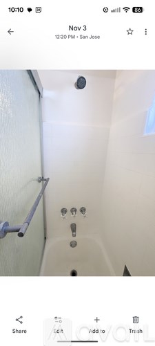A white bathroom with a shower and a toilet.