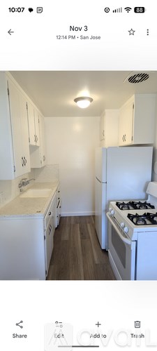 A small, white kitchen with a stove and a sink.