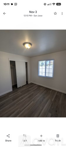 A room with wooden flooring and a window.