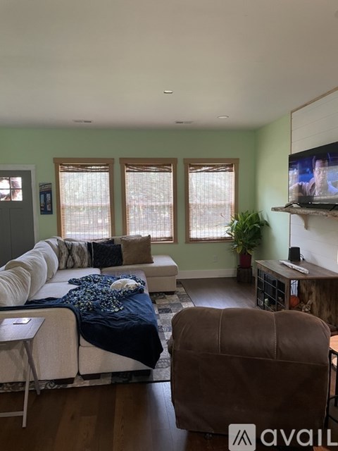 A living room with a white couch and a brown chair.