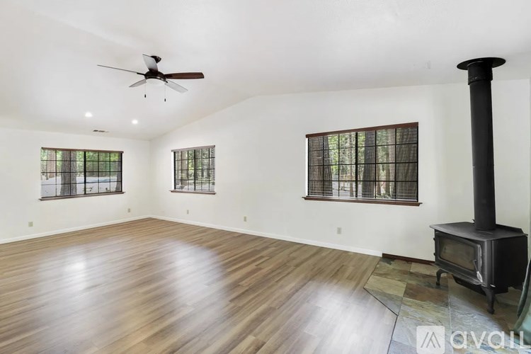 A living room with a wood floor and a wood stove.
