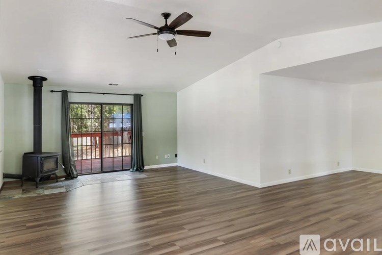 A room with a wood floor and a ceiling fan.