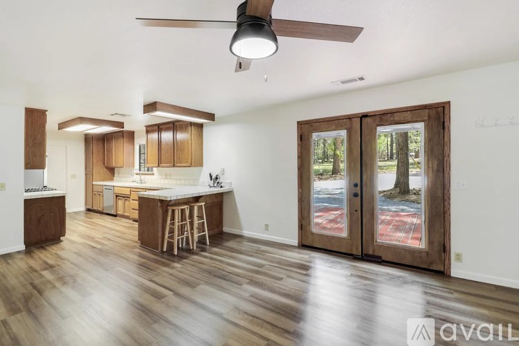 A kitchen with wooden floors and a ceiling fan.