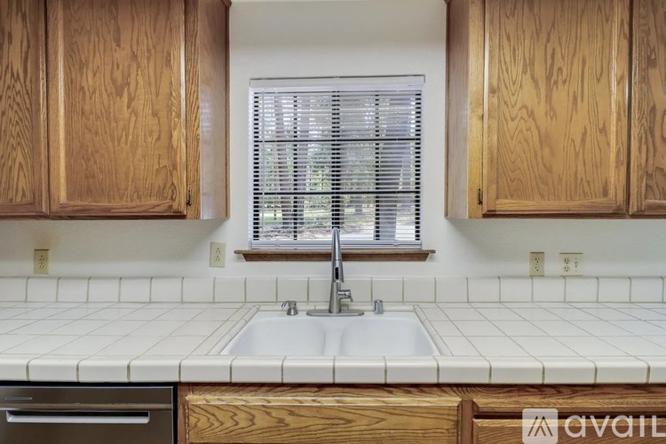 A kitchen with wooden cabinets and a white sink.