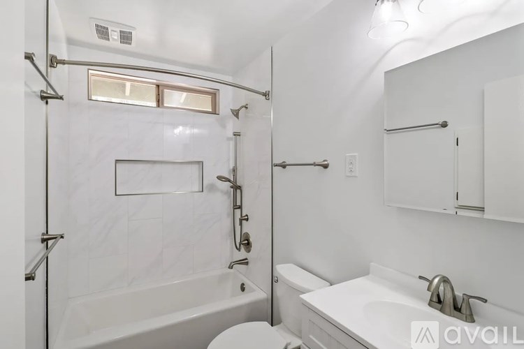A white bathroom with a tub, sink, and toilet.