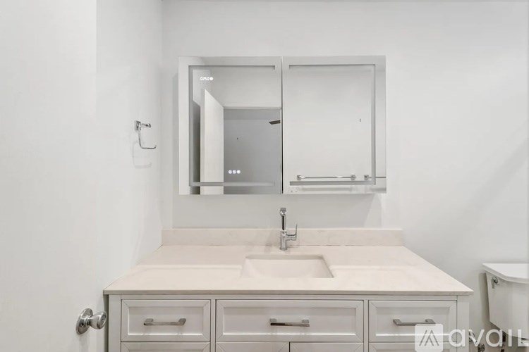 A white bathroom with a sink and mirror.