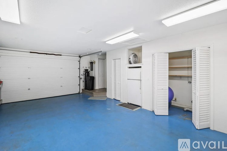 A spacious garage with a blue floor and white walls.