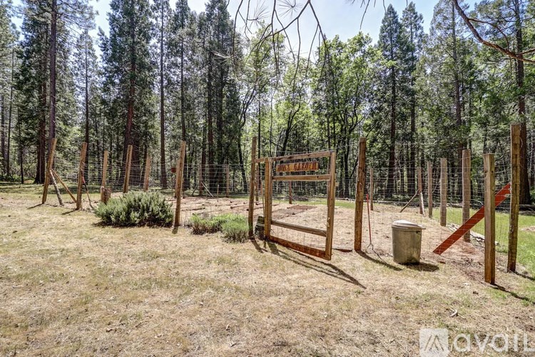A sign in a field with trees in the background.