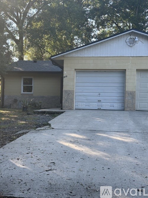 A two-story house with a garage door and a driveway.