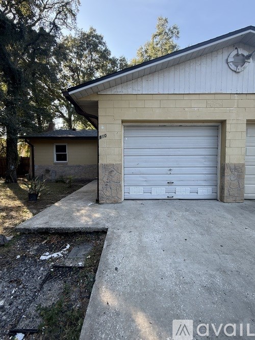 A garage with a white door is attached to a house.