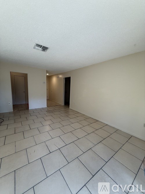 A room with tiled flooring and two doors.