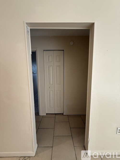 A white door is in a white room.