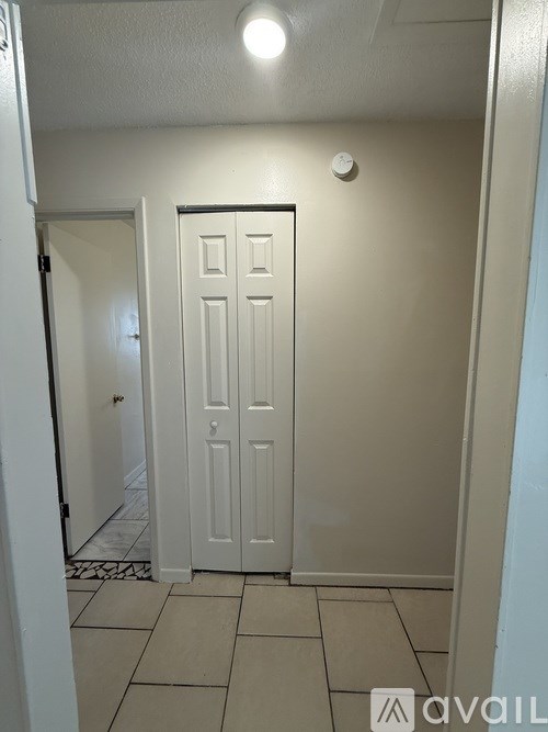 A white door in a room with tiled flooring.