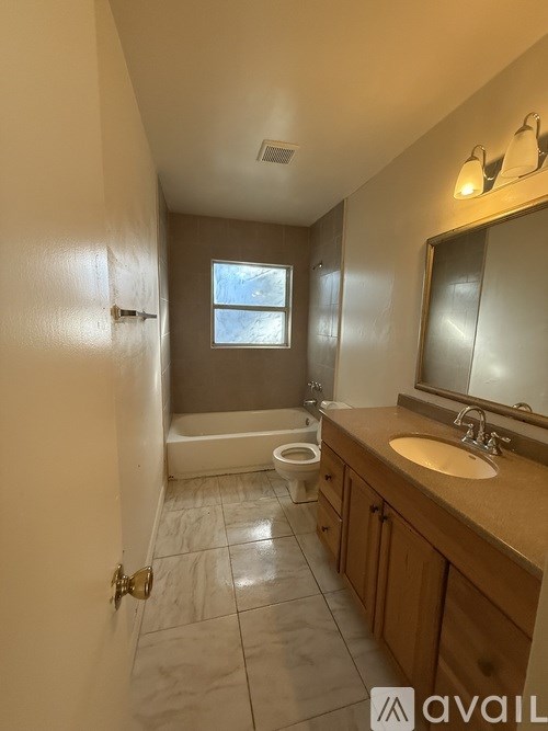 A bathroom with a toilet, sink, and tub.