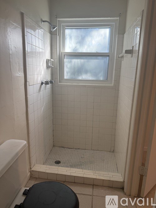 A bathroom with a toilet, tub, and window.
