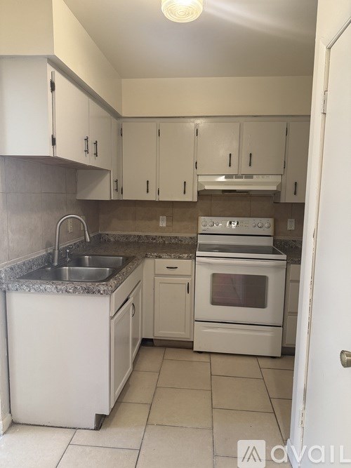 A kitchen with white appliances and cabinets.