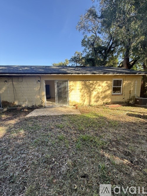 A house with a faded yellow exterior and a brown roof.