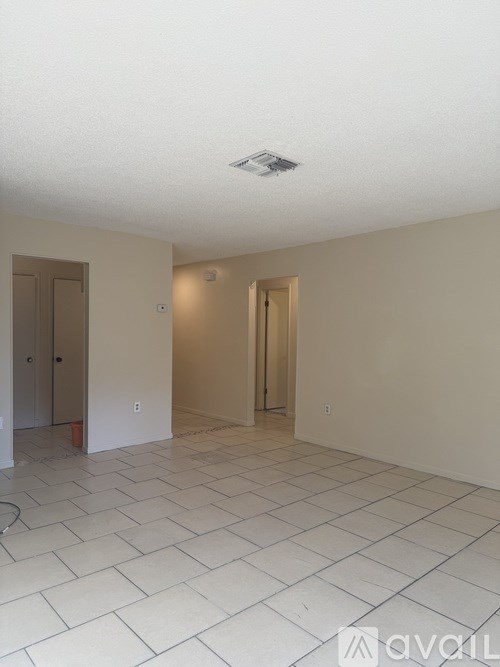A room with a white tile floor and two doors.