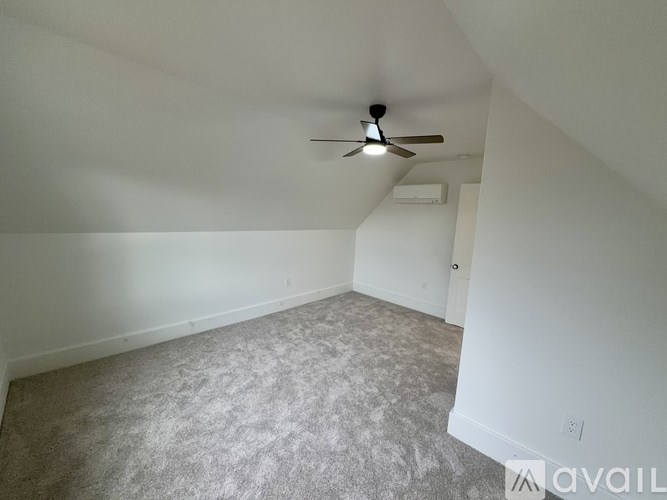A room with a ceiling fan and carpeted floor.
