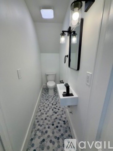 A bathroom with a toilet and a mirror.