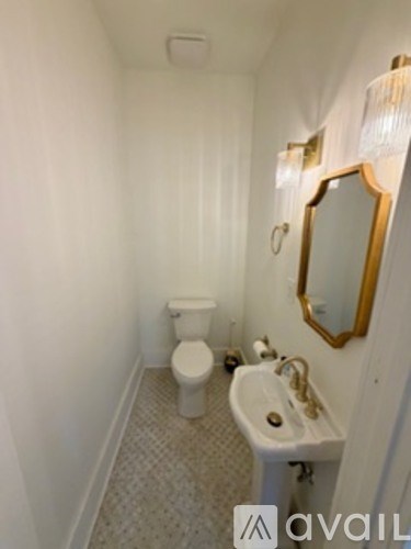 A small bathroom with a toilet, sink and mirror.