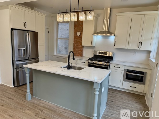A kitchen with a white island and a refrigerator.