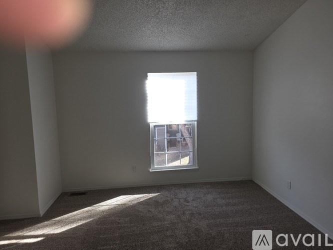 A room with a window and carpeted floor.