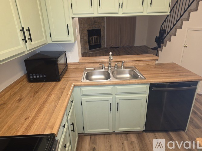 A kitchen with a sink and a microwave on the counter.