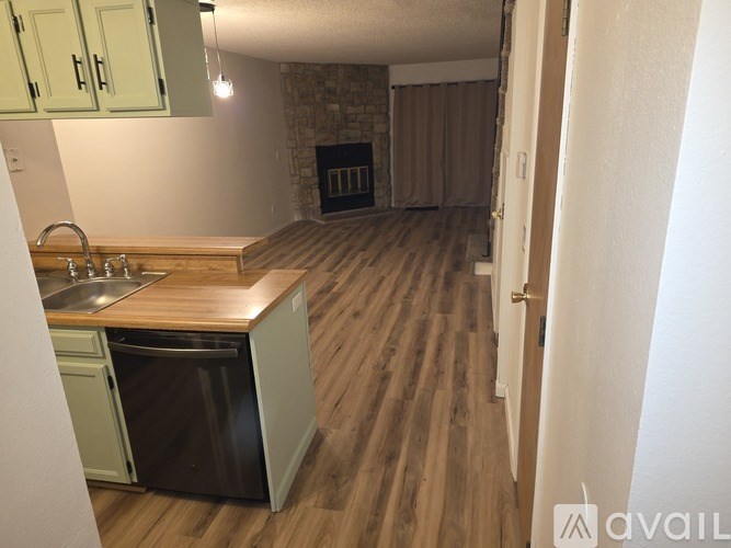A kitchen with a sink, dishwasher, and a wood-burning stove.