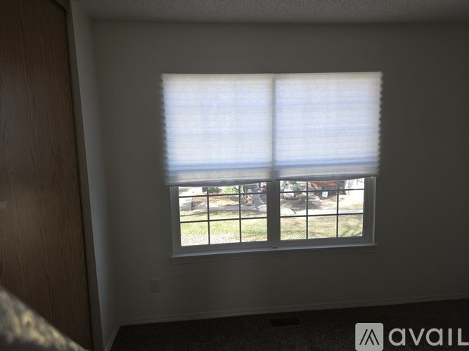 A window with blinds overlooking a balcony.