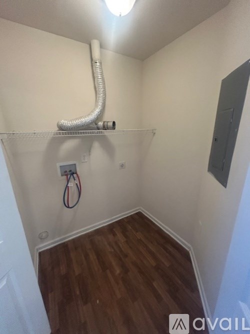 A room with a white wall and a wooden floor.