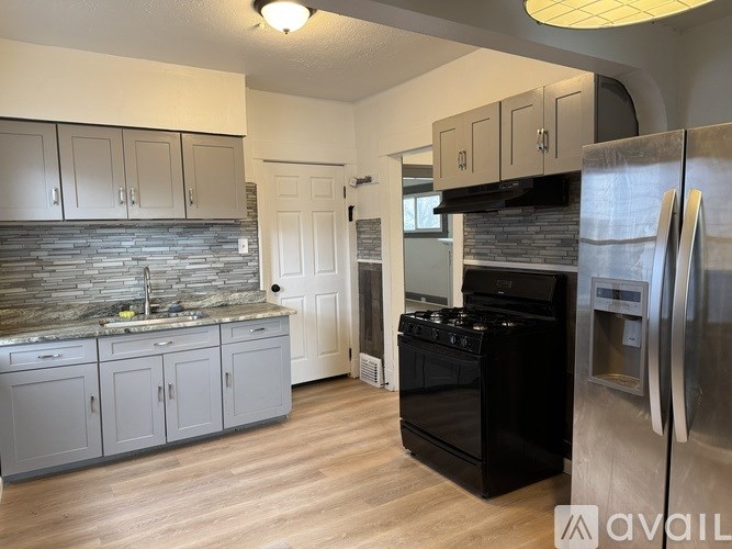 A kitchen with a black oven and stainless steel refrigerator.