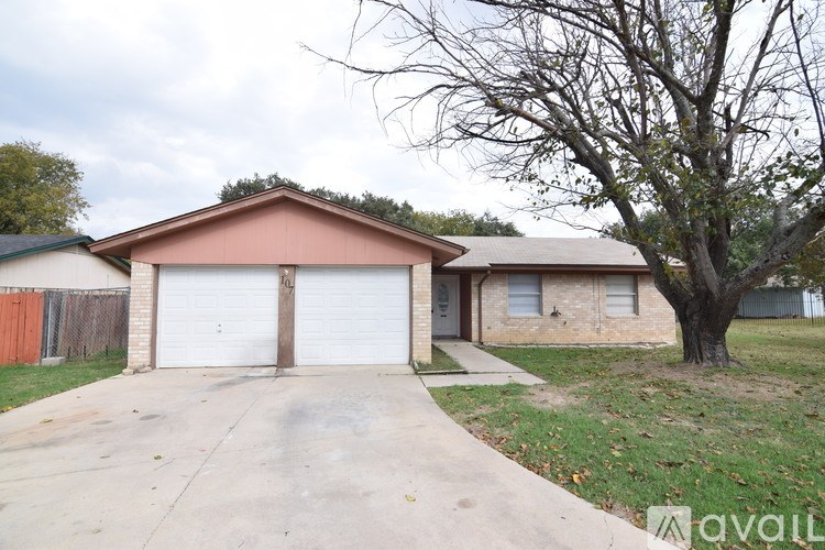A house with a brown roof and two white garage doors.