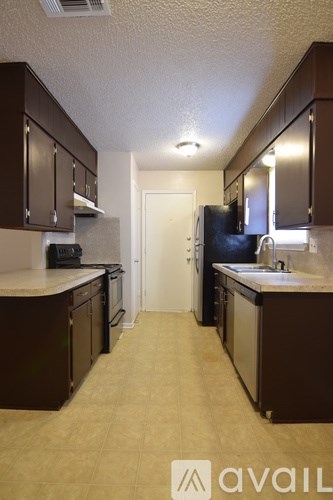 A kitchen with brown cabinets and a white counter top.