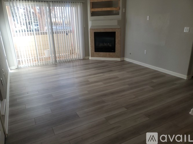 A room with a fireplace and wooden flooring.