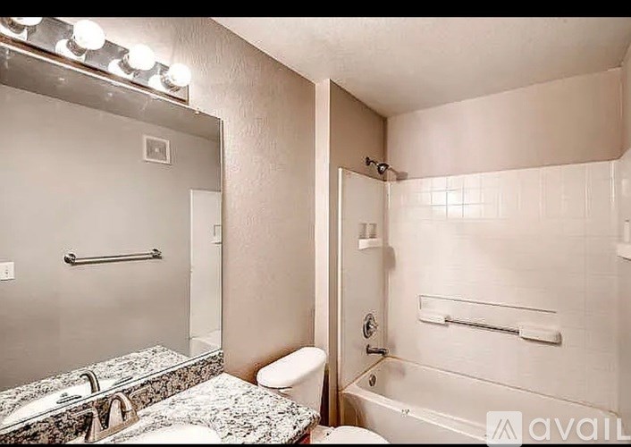 A bathroom with a marble countertop and a walk-in shower.