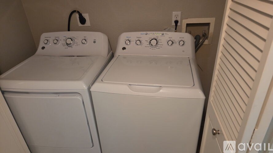 Two white front loading washing machines in a small laundry room.