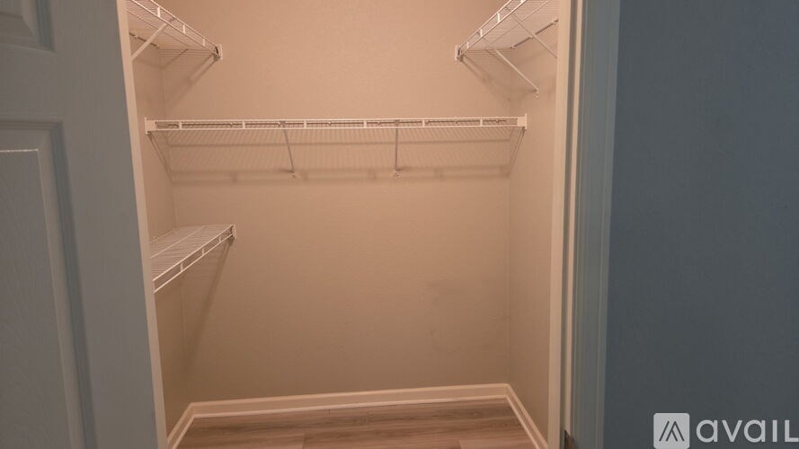 Empty white refrigerator with shelves and racks.